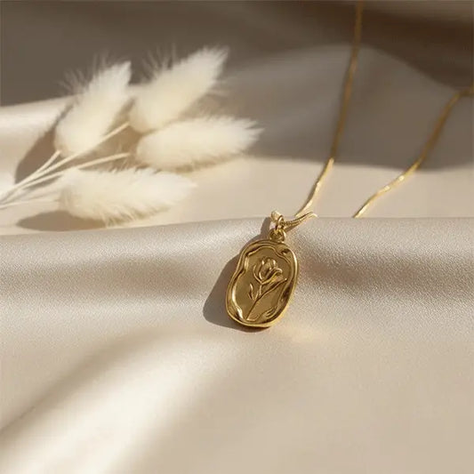 Gold Serenity Pendant close-up featuring elegant oval pendant on smooth satin background with warm natural light
