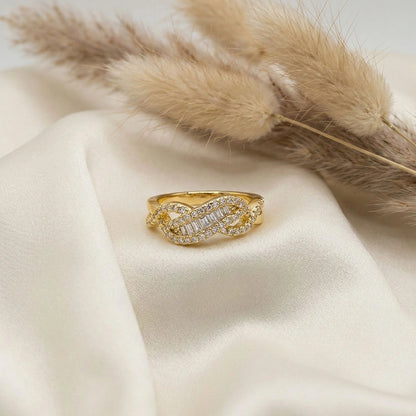 Gold anti-tarnish knot ring detailing placed on soft ivory satin fabric with pampas grass for an elegant jewellery flatlay.