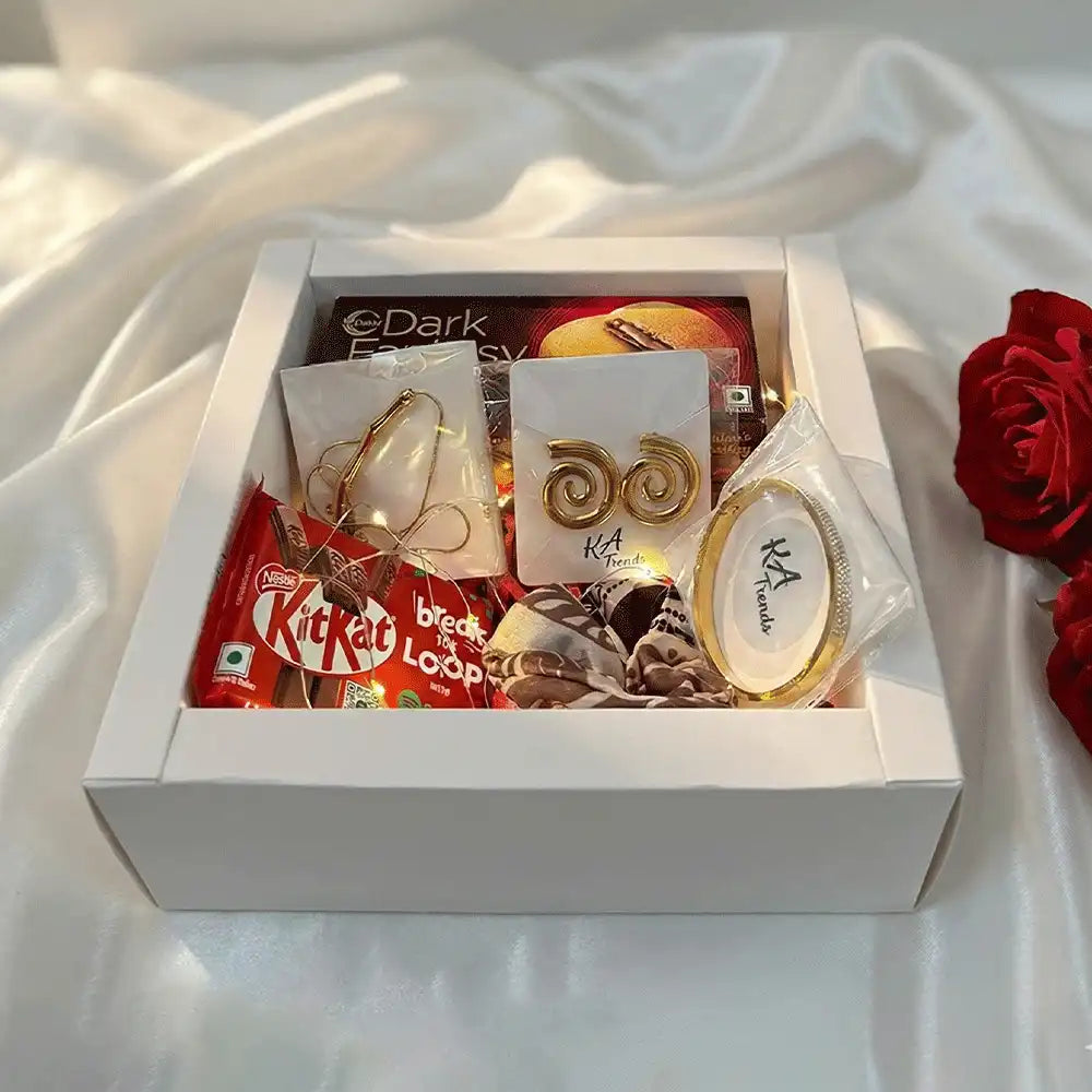 Luxury Golden Statement anti-tarnish jewellery and chocolate gift hamper with spiral earrings, bracelet, Dark Fantasy chocolates, and KitKat, styled in a premium white box on satin fabric.