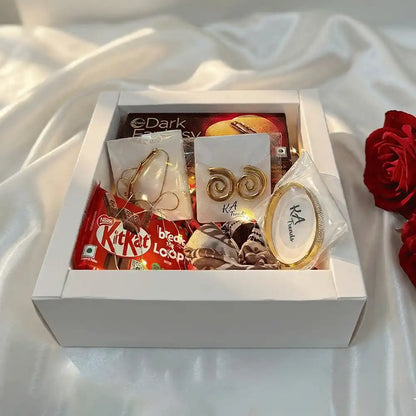 Luxury Golden Statement anti-tarnish jewellery and chocolate gift hamper with spiral earrings, bracelet, Dark Fantasy chocolates, and KitKat, styled in a premium white box on satin fabric.