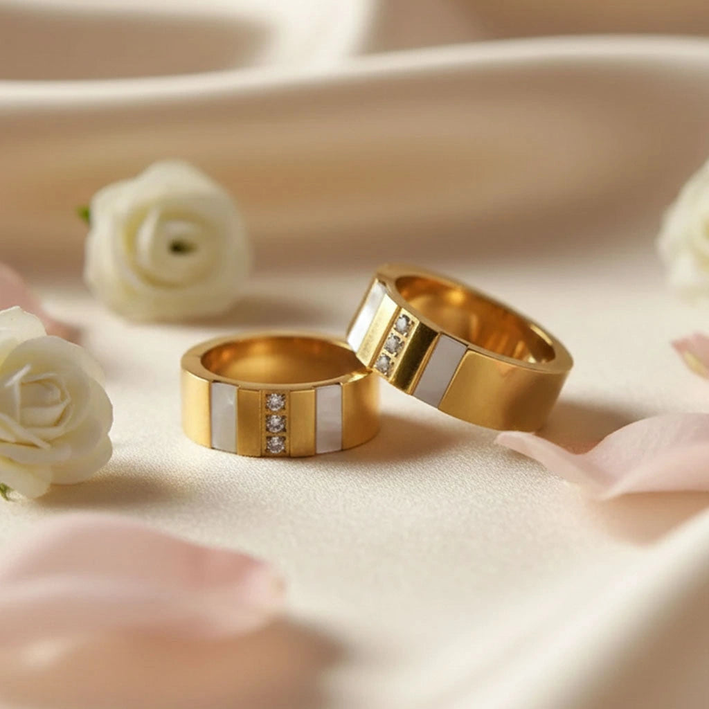 Gold anti-tarnish hoop earrings with crystal strip and white enamel displayed on soft fabric with white roses.