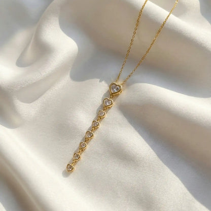 Heart Cascade Pendant anti-tarnish gold heart drop pendant necklace on white satin