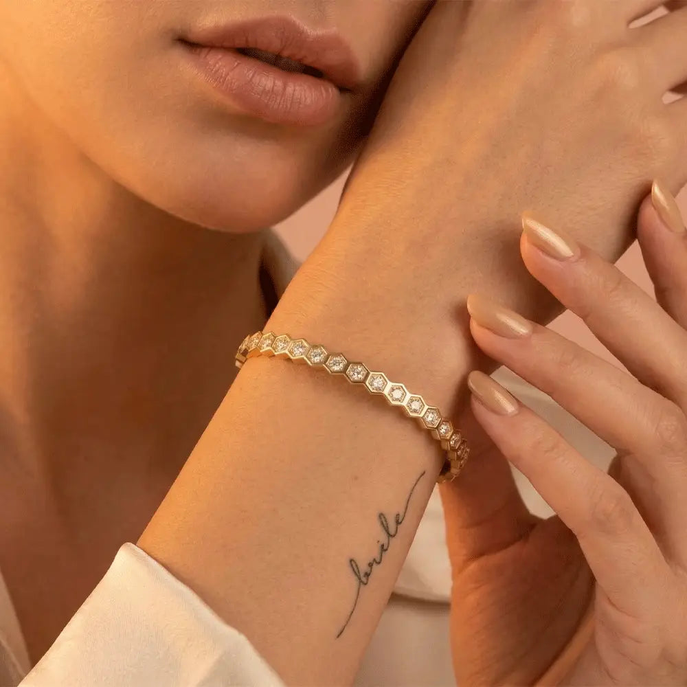 Hexagon crystal gold bracelet worn on wrist, featuring geometric hexagon links with sparkling stones.