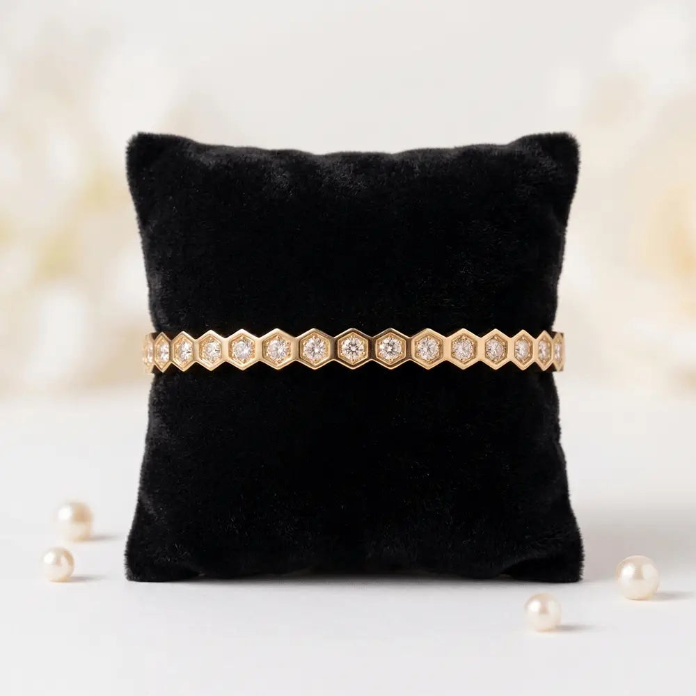 Hexagon crystal gold bracelet displayed on black velvet cushion, elegant hexagon pattern with shimmering crystals.