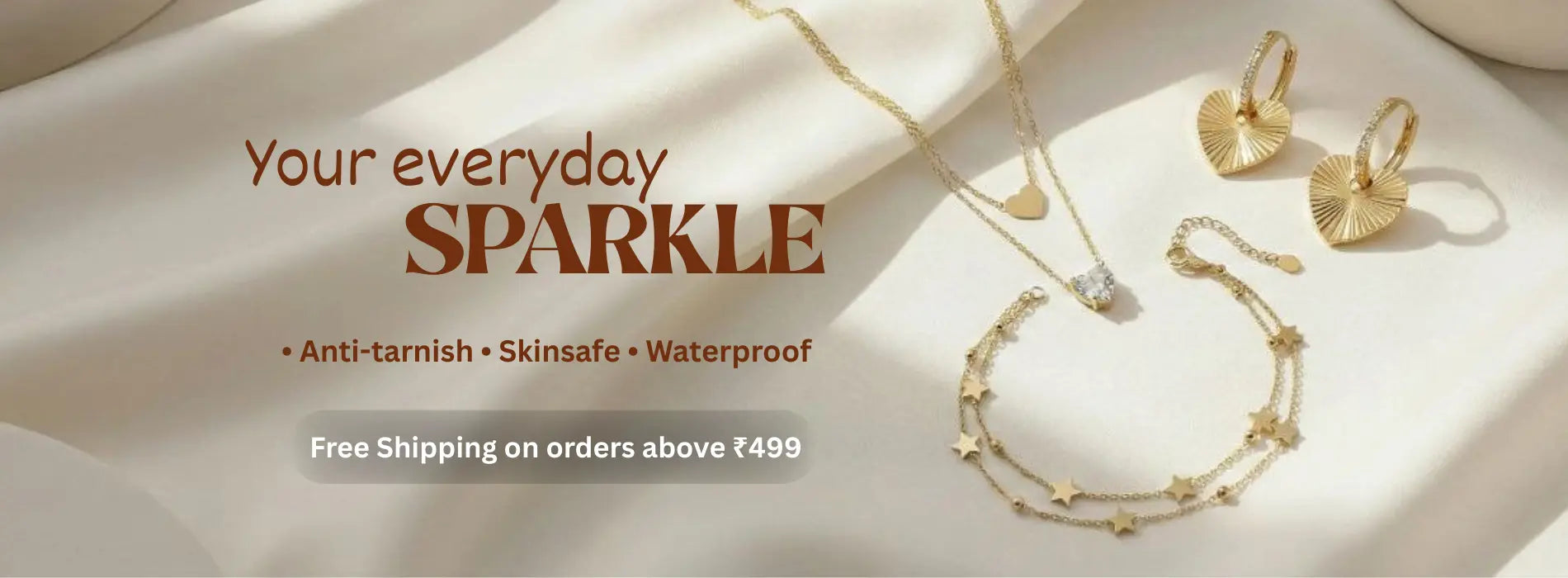 Gold jewelry set including necklace, earrings, and bracelet on a soft fabric background with promotional text.