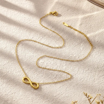 K-A Trends anti tarnish gold infinity pendant necklace on beige textured background minimalist jewellery flatlay