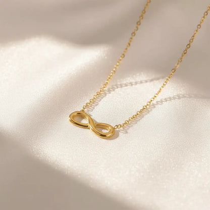 K-A Trends anti tarnish gold infinity pendant necklace on white satin luxury aesthetic product shoot