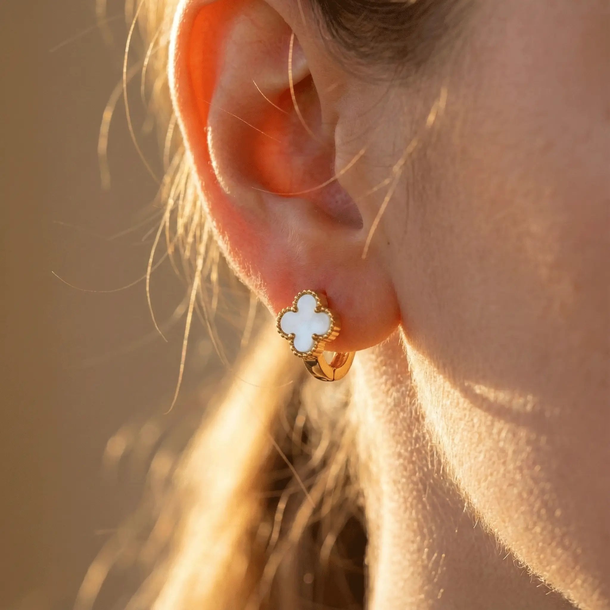 Close-up of Ivory Clover Hoops earring highlighting clover shape and smooth white inlay in warm sunlight