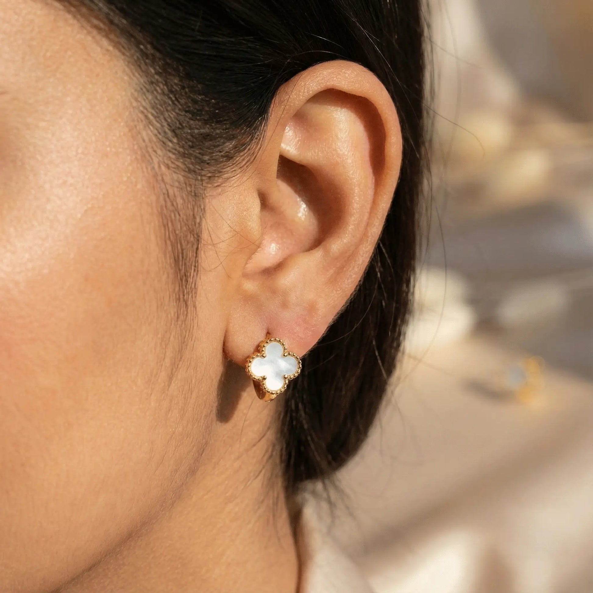 Ivory Clover Hoops worn by Indian woman in ear close-up showing elegant clover design in natural sunlight