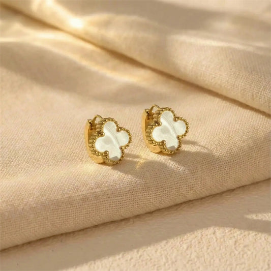 Pair of Ivory Clover Hoops earrings displayed on neutral fabric background with soft luxury lighting