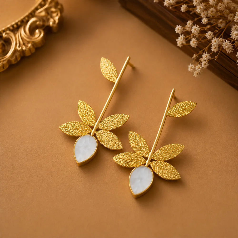 Angled view of Ivory Leaf anti tarnish brass earrings featuring botanical leaf detailing and elegant white teardrop stones.