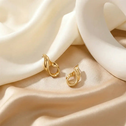 Luxury liquid gold stud earrings on flowing white fabric background, anti tarnish gold earrings for daily and party wear