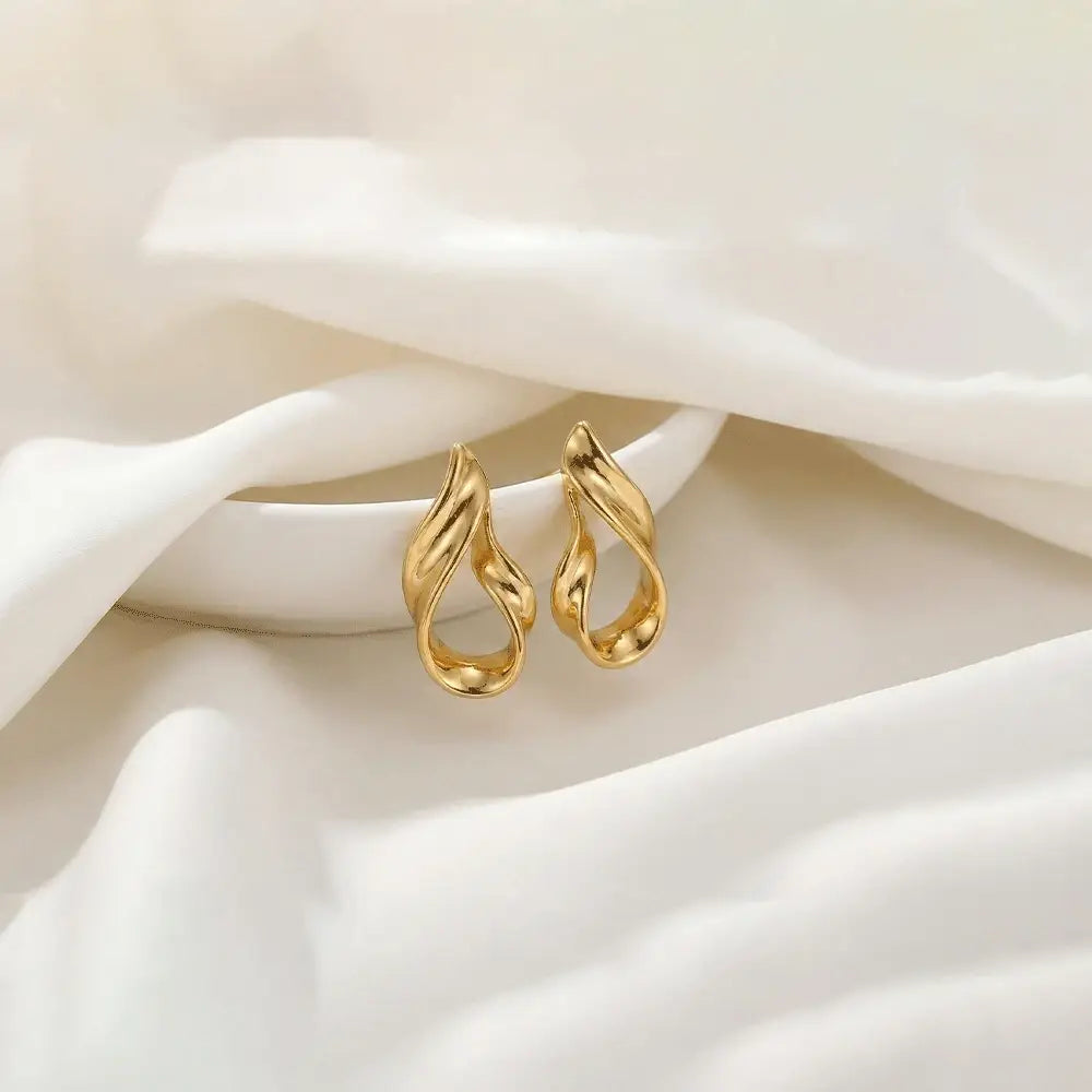 Liquid gold stud earrings in glossy gold finish placed on soft white satin fabric, anti tarnish lightweight designer earrings by K-A Trends