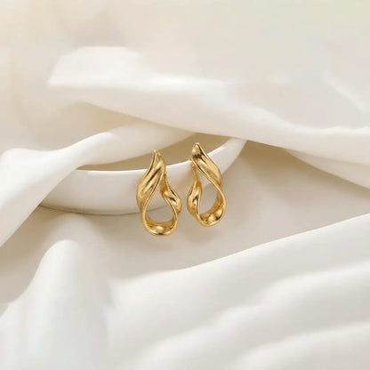 Liquid gold stud earrings in glossy gold finish placed on soft white satin fabric, anti tarnish lightweight designer earrings by K-A Trends