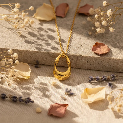 Dainty gold-plated necklace featuring a textured, irregular, molten metal pendant.