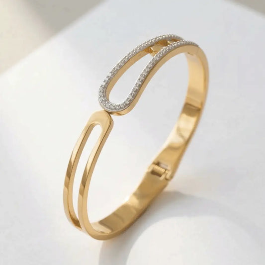 Loop crystal gold bracelet with curved open design and sparkling crystal detailing.