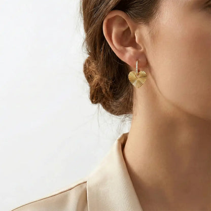 Model wearing gold heart hoop earrings with textured heart charm, anti tarnish love hoops earrings by K-A Trends
