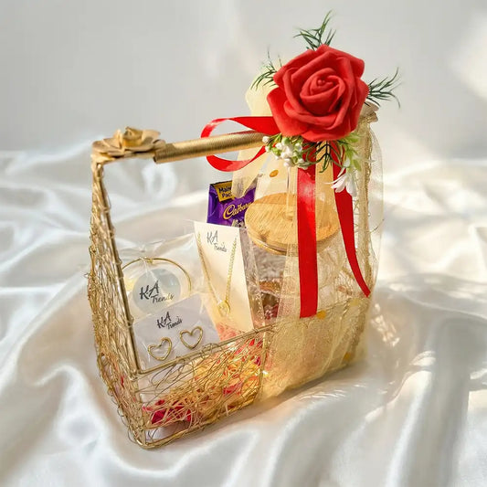 Valentine luxury jewellery hamper featuring anti-tarnish heart-shaped earrings, delicate bracelet, pendant necklace, chocolates, and fairy lights, styled in a gold wire basket with red rose décor.