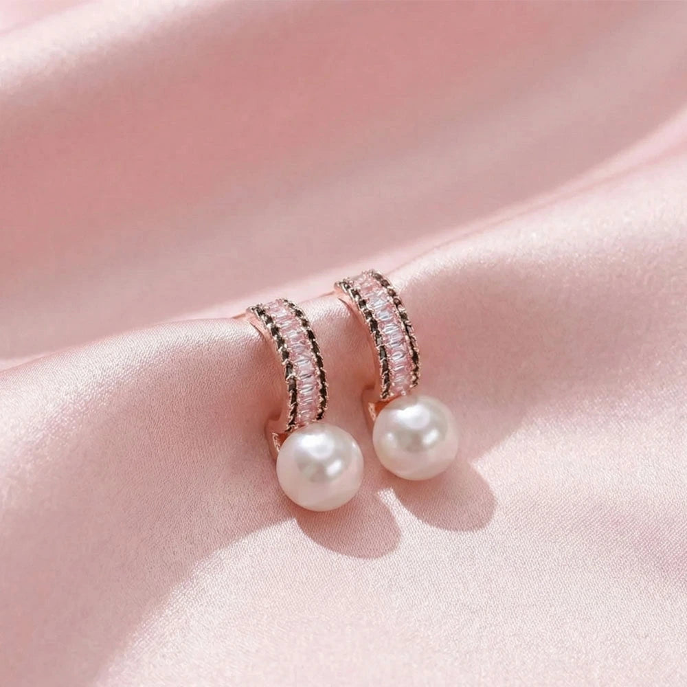 Luxe Pearl Earrings – Anti-Tarnish rose gold crystal-studded hoops with a pearl drop placed on pink satin.
