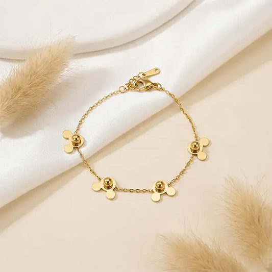 Mini Mouse Bracelet anti-tarnish charm bracelet arranged in circular shape on satin surface with pampas grass