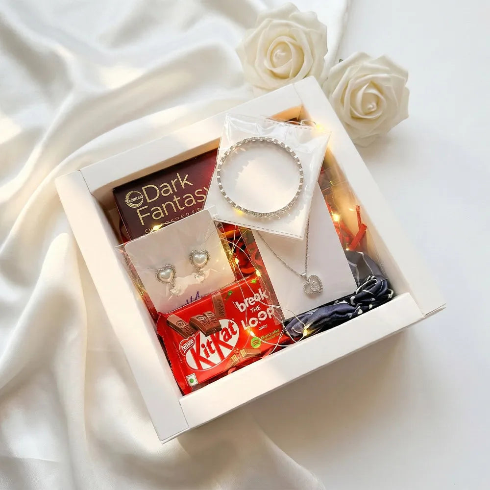 Luxury Valentine gift hamper with anti-tarnish silver heart necklace, matching earrings, crystal bangle, chocolates, fairy lights, and white roses in premium box