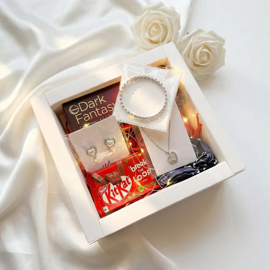 Luxury Valentine gift hamper with anti-tarnish silver heart necklace, matching earrings, crystal bangle, chocolates, fairy lights, and white roses in premium box