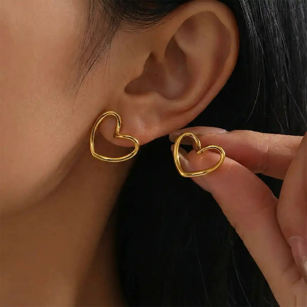Model wearing open heart gold stud earrings, showing the lightweight design and modern heart outline for everyday wear.