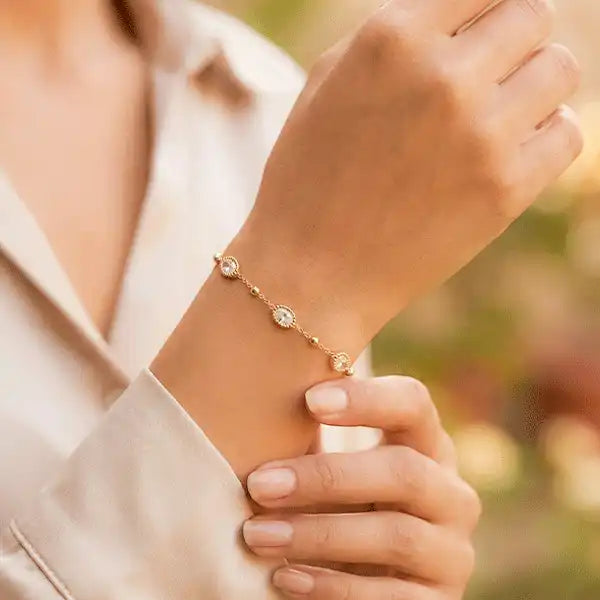 Anti-tarnish gold oval stone chain bracelet worn on a woman’s wrist, featuring delicate oval zircon stones in a minimal everyday design