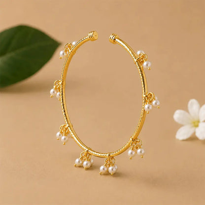 Close-up of Pearl Charm anti tarnish brass bracelet featuring cascading pearl cluster charms and an elegant gold-toned open bangle design.