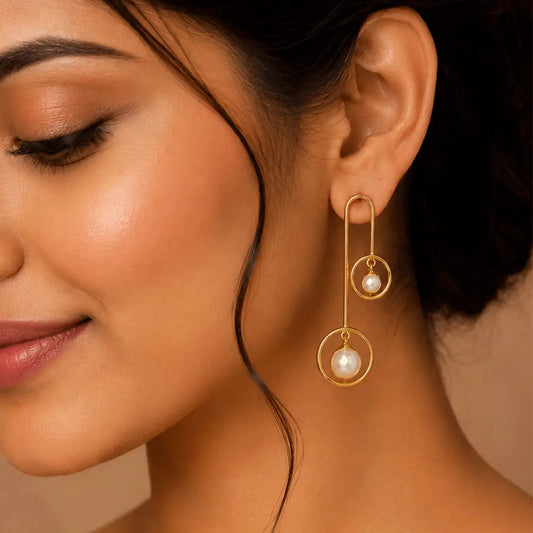 Indian model wearing Pearl Orbit anti tarnish brass earrings featuring geometric gold circles and elegant pearl drop accents.