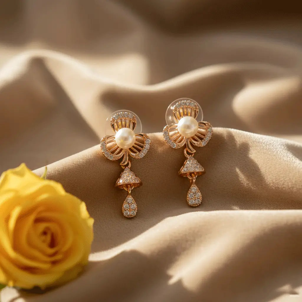 Rose gold pearl petal AD drop earrings with shimmering stones photographed on beige fabric with a yellow rose.