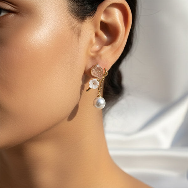 Model wearing floral pearl drop earrings in gold colour