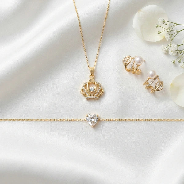 A gold jewelry set displayed on a soft white fabric background with white flowers placed nearby for an elegant, romantic presentation.