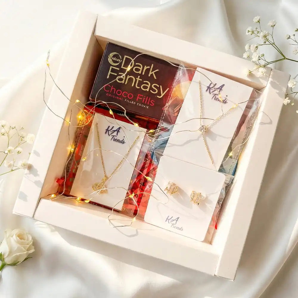 Queen of My Heart anti-tarnish jewellery hamper including delicate gold-tone necklace, stud earrings, chocolates, and fairy lights, beautifully arranged in a white box with floral accents.