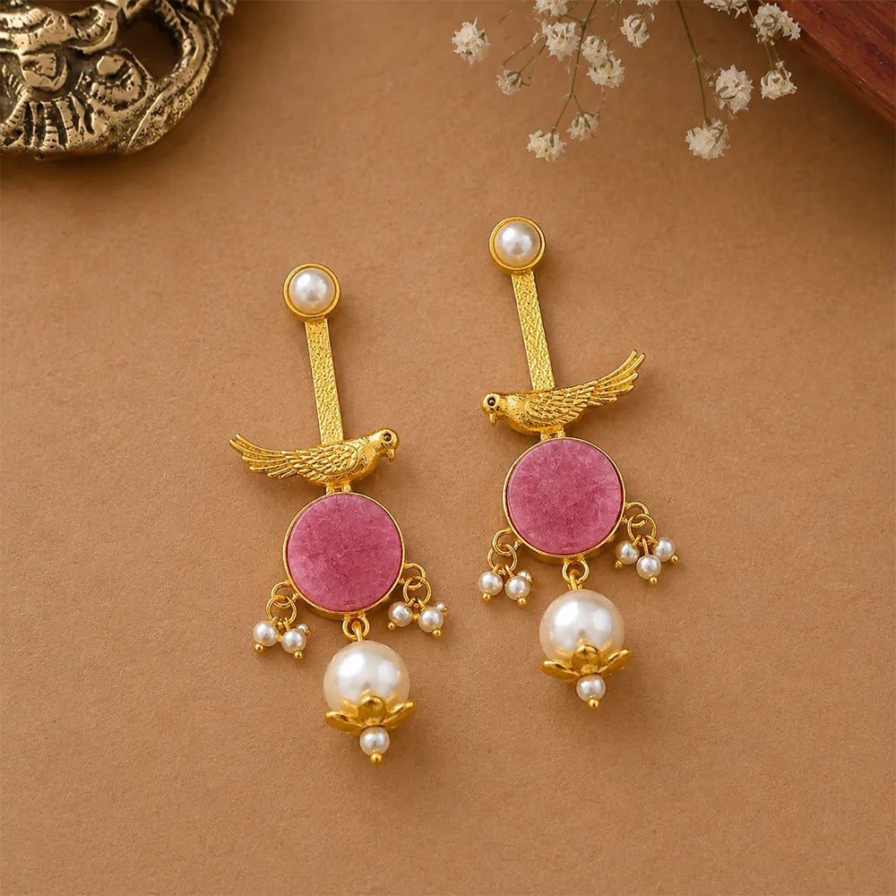 Angled view of Rosy Sparrow anti tarnish brass earrings featuring pink stones, sparrow-inspired brass detailing, and pearl drop accents.