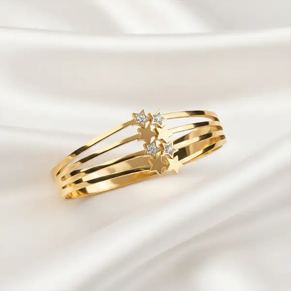 Shooting Star Bracelet by K-A Trends in anti-tarnish finish, star-detailed gold-tone bracelet displayed on soft white satin fabric