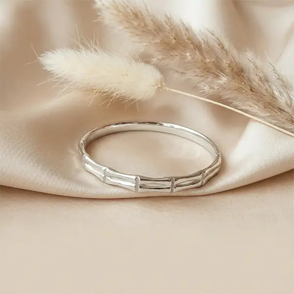 Silver Stack Bracelet anti-tarnish silver-tone bracelet placed on soft satin fabric with dried pampas grass