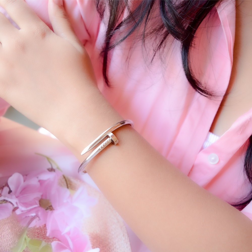 Silver Nail Bracelet on a wrist with a soft pink background