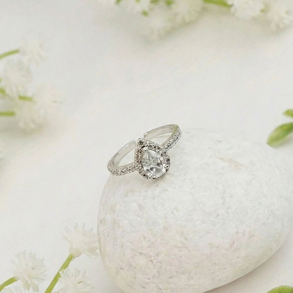 Silver Teardrop ring with a diamond on a white stone surrounded by white flowers