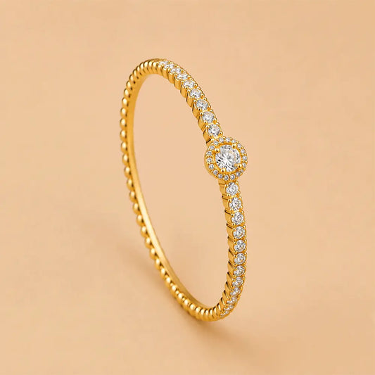 Solitaire Beaded Bracelet featuring a twisted rope design, pavé-set clear stones, and a central round-cut diamond surrounded by a halo, set against a solid peach background.