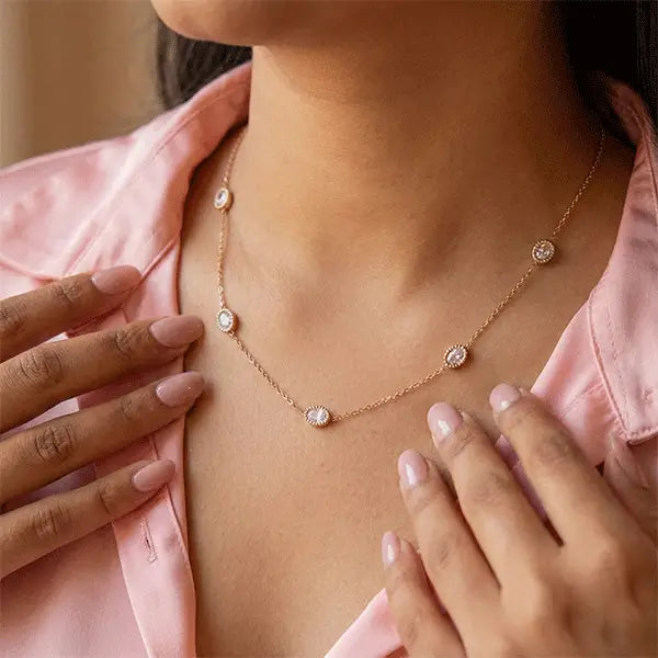 Woman wearing the rose-golden Sparkle Chain Pendant Necklace with oval crystal charms, paired with a pink outfit.