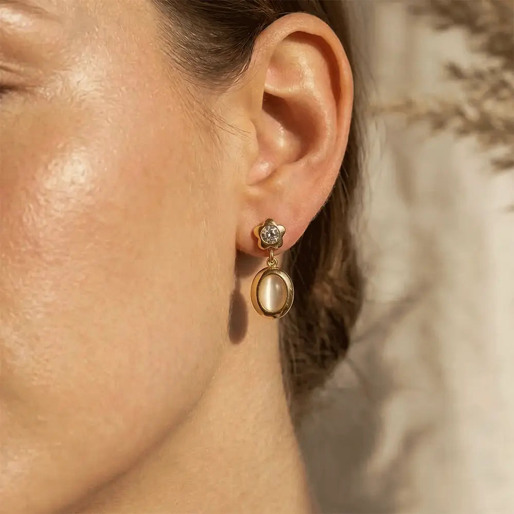 Star Spark Oval Drops with a pearl-like center worn by a person.