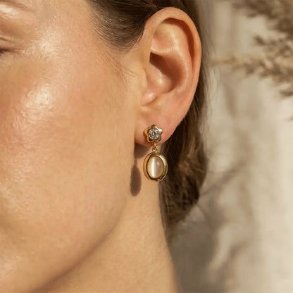 Star Spark Oval Drops with a pearl-like center worn by a person.