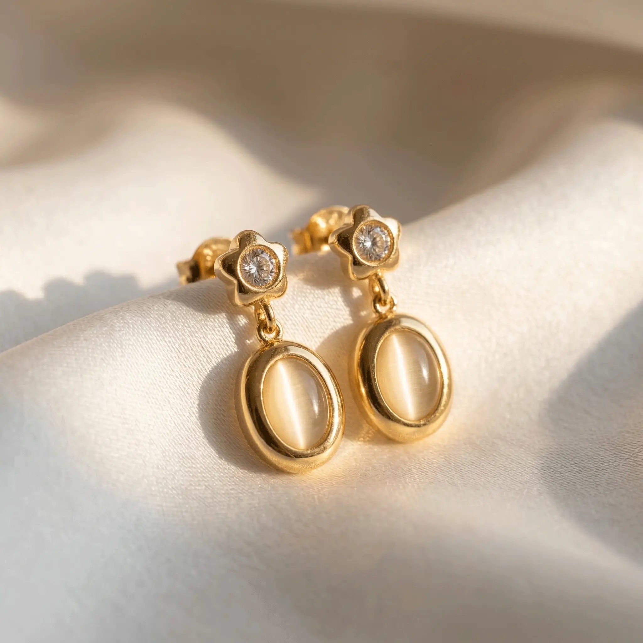 Star Spark Oval Drops with gemstones on a light fabric background