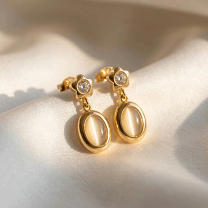 Star Spark Oval Drops with gemstones on a light fabric background