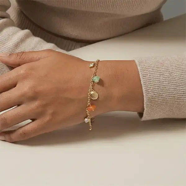 Women wearing delicate gold stone charm bracelet on wrist, minimalist everyday jewellery