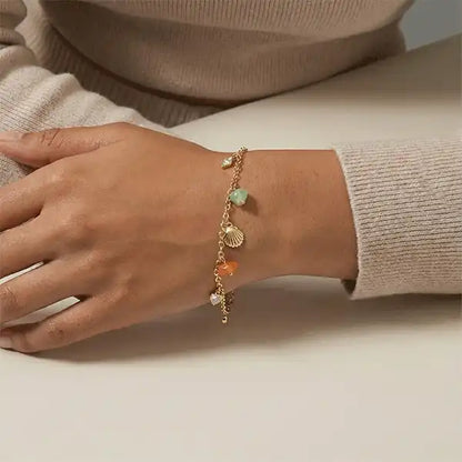 Women wearing delicate gold stone charm bracelet on wrist, minimalist everyday jewellery
