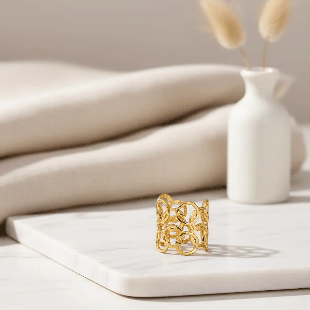 Sunshine Petal Ring with open-circle gold design displayed on a white marble slab with neutral decor.