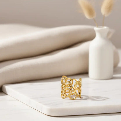 Sunshine Petal Ring with open-circle gold design displayed on a white marble slab with neutral decor.