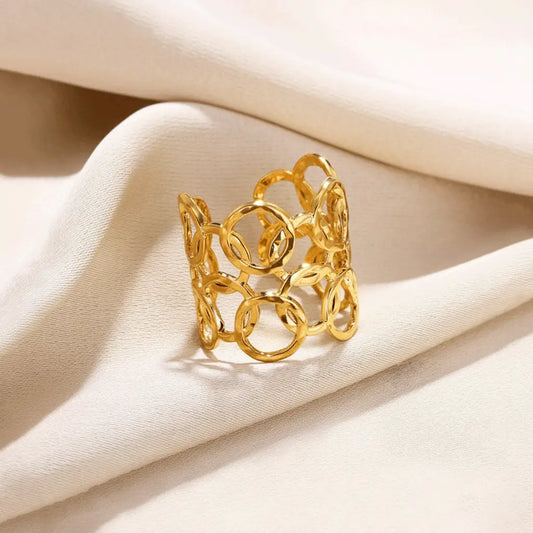 Gold Sunshine Petal Ring featuring layered open-circle pattern placed on soft beige fabric.